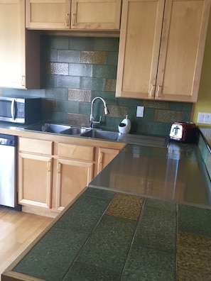 Countertops and splash are handmade tile from Trinidad and trimmed in solid oak