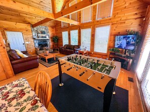 Cozy leather furniture, a stone woodburning fireplace and foosball making this living area a place for everyone to hang out.