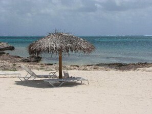 Large private beach with shade and lounges.