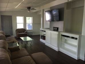 Newly updated living room overlooking back yard with hot tub, patio, & fire pit