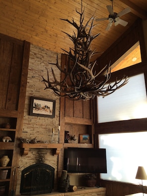 flat screen TV and antler chandelier in main living area