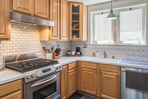 Generous kitchen space, modern appliances, and cooking utensils.