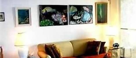 Living room with futon couch and reef fish pictures.