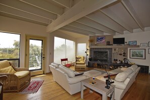 Living Room w/fireplace opens to front deck and the ocean view beyond