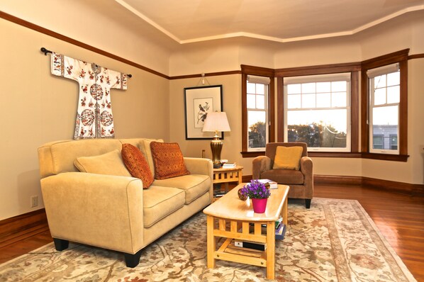 Bright, airy living room with gas fireplace and bay windows.