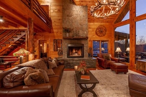 Great Room featuring Stunning Window Wall, Stone Wood-burning Fireplace & Leather Furnishings