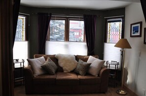 Bay window room off living room with queen sleeper couch and mountain views