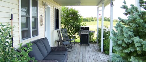 Relax on the covered porch with views of the barns and east valley.