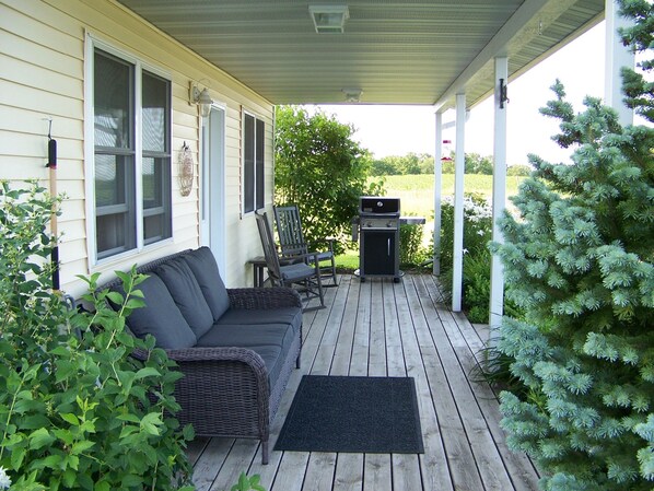 Relax on the covered porch with views of the barns and east valley.