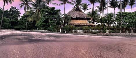 This beachfront bungalow with pink sunsets awaits you!