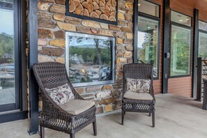 Relax on the patio with cozy seating, stone fireplace, and serene lake views.