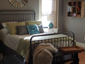 queen size bed located next to a small library