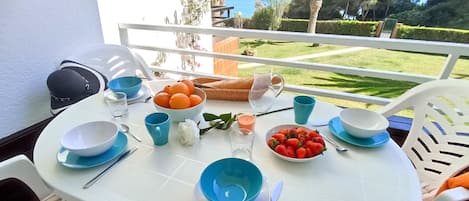 Terraza con vista al mar y espacio verde compartido.