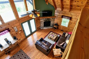 Large, open den boasts a 55" HDTV, cathedral ceilings and a sleeper sofa.