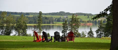 Peaceful scene as you pull up the driveway.  Adirondack chairs at fire pit.