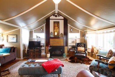 Spacious living room with tented cathedral ceiling and adorned fireplace