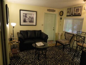 New black Betrillo deco couch with Steve McQueen art and Zebra carpet and chair