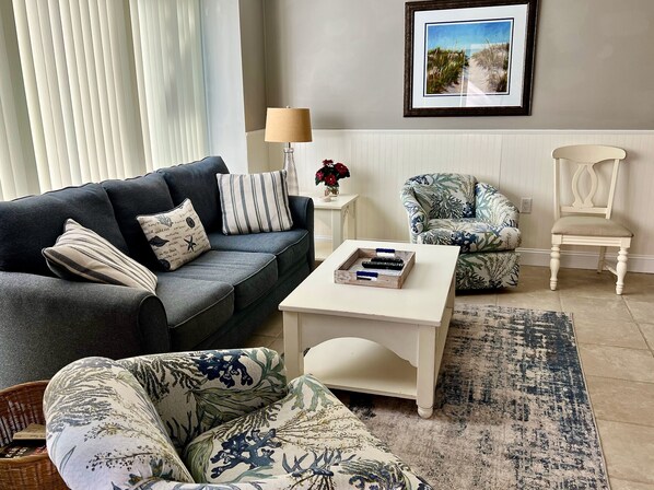 Living room with balcony and outdoor dining table and chairs.