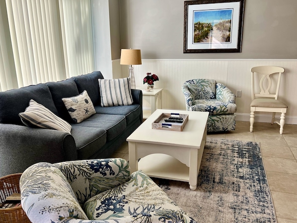 Living room with balcony and outdoor dining table and chairs.
