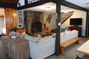 Sectional sofa faces the massive stone fireplace.