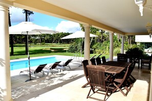 Outside covered living and dining area overlooking the pool