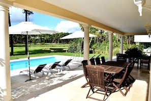 Outside covered living and dining area overlooking the pool