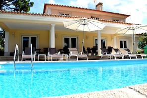 Outside covered living and dining area overlooking the pool