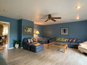 Living room South West view. 2 sofas, 2 lounge chairs, love seat, TV.