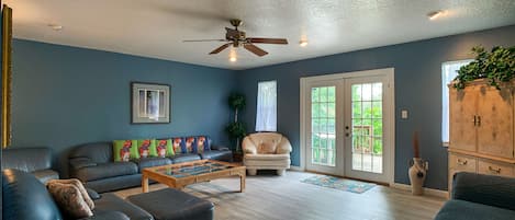 The large living room has french doors that open out to the deck. 2 sofas, TV