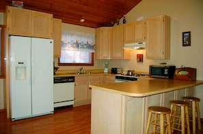 Kitchen with a gas stove, dishwasher and additional seating for three