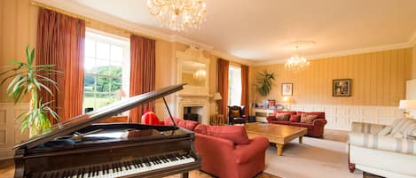 An amazing light filled room, wood burner, baby grand piano, 3 sofa's. Glorious!