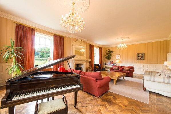 An amazing light filled room, wood burner, baby grand piano, 3 sofa's. Glorious!