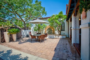 Front courtyard with outdoor dining.  Madagascar silk pod tree in front yard. 