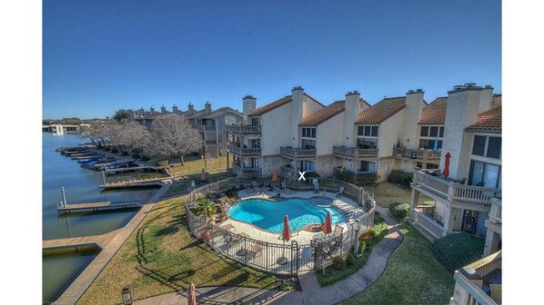 Aerial view of condo, swimming pool, and lake; X is our condo