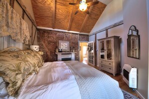 Master bedroom, king bed, flat screen TV, and fireplace. 