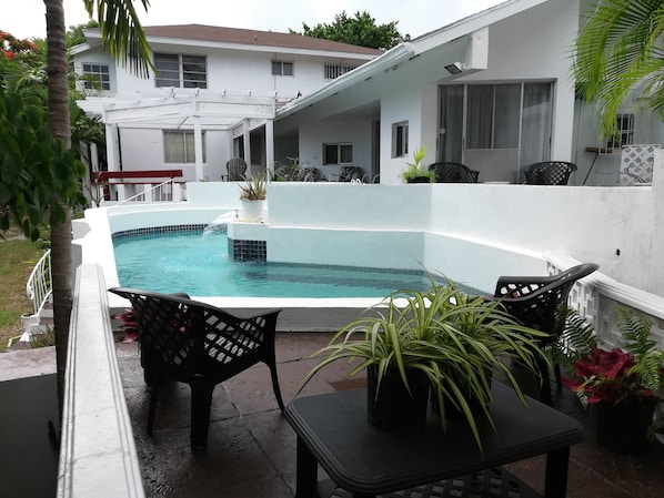 Inviting view of the tree-shaded Lower Pool Deck, with Upper Deck/Patio in view.