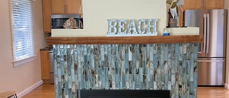 The focal point upon entry is our fireplace covered with sea glass tiles.