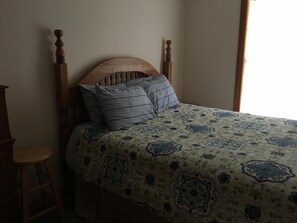 Queen bed in bedroom to itself in basement area. 