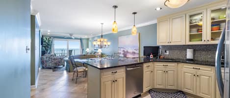 BREAKFAST BAR AT KITCHEN WITH GRANITE COUNTER TOPS. BAR ALSO HAS A TV. 