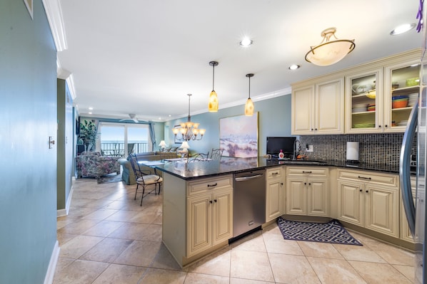 BREAKFAST BAR AT KITCHEN WITH GRANITE COUNTER TOPS. BAR ALSO HAS A TV. 