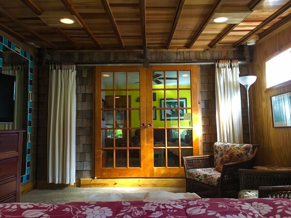 Bedroom looking towards living room. Beautiful restored sliding french doors. 