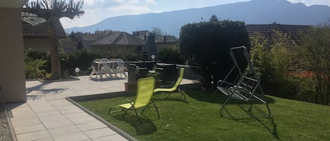 Terrasse donnant sur pelouse et barbecue