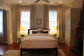 Luxury Bedroom with exposed brick fireplace, ceiling fan and blackout curtains!