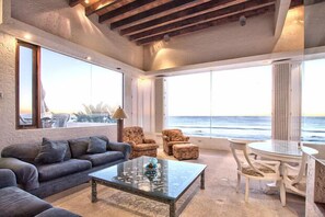 Big ocean view windows, tall wood beam ceilings.