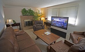 LIVING ROOM WITH ALL LEATHER FURNITURE, FIREPLACE AND WIDESCREEN TV.