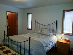 Master bedroom with queen bed, attached bathroom and walk-in closet