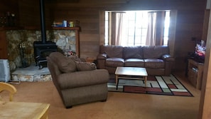 Living room with open layout, wood stove, flat screen tv, dvd player and more!