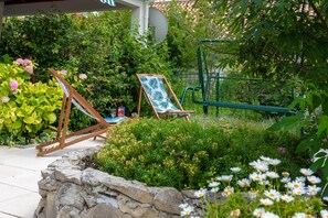 Terrace with a sitting area, garden and outdoor fireplace/grill.