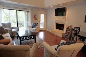 Another view of living room that looks out to the lagoon, deck and screen porch