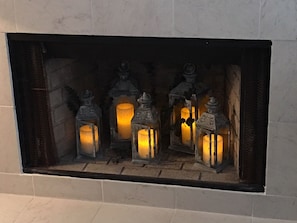 Newly refaced, marble, decorative fireplace with lanterns